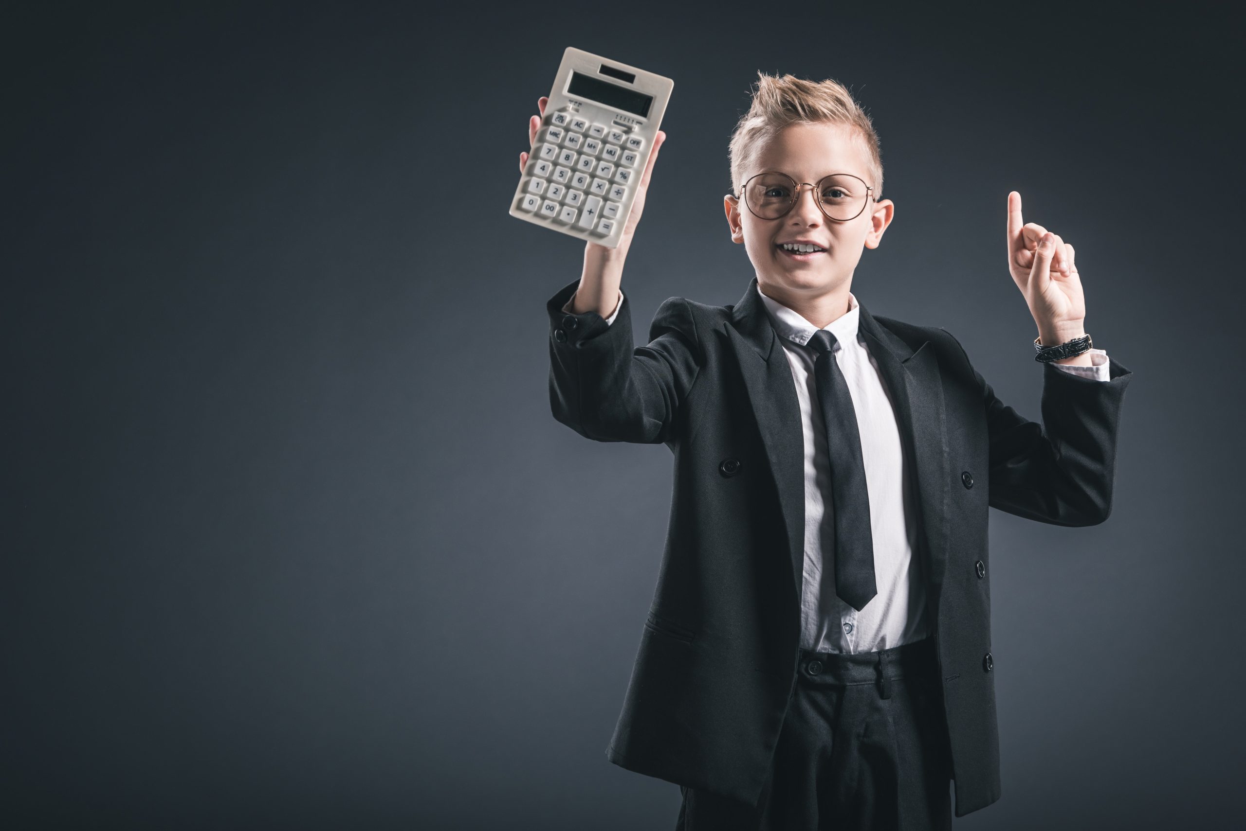 Boy in suit holding calculator